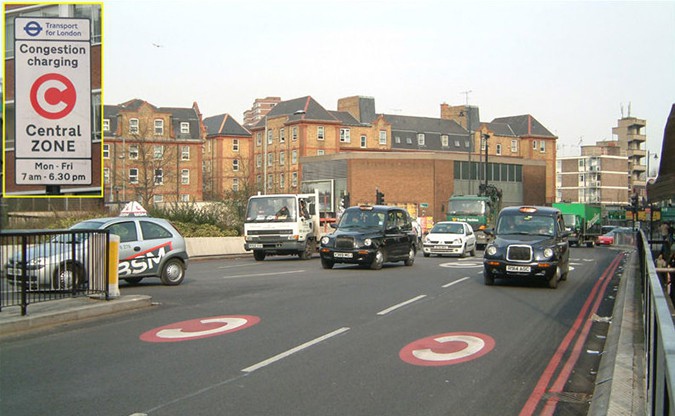 Уличная разметка и знак с красным кружком с белой буквой С внутри на Олд стрит предупреждает водителей о плате за въез